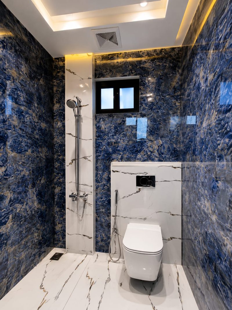 Shower room clad in blue figured stone with a marble floor — Reef Al Ghadeer, Al Ain