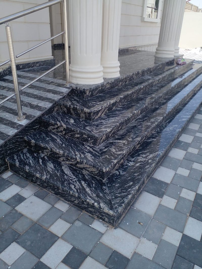 Granite entrance platform and step edge laid over patterned block paving — Reef Al Ghadeer, Al Ain