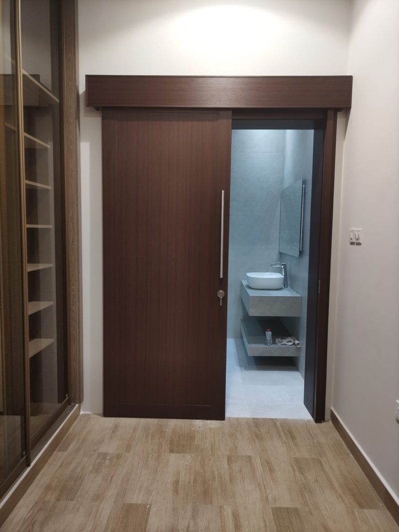 Interior timber door and frame opening onto a completed washroom — Reef Al Ghadeer, Al Ain