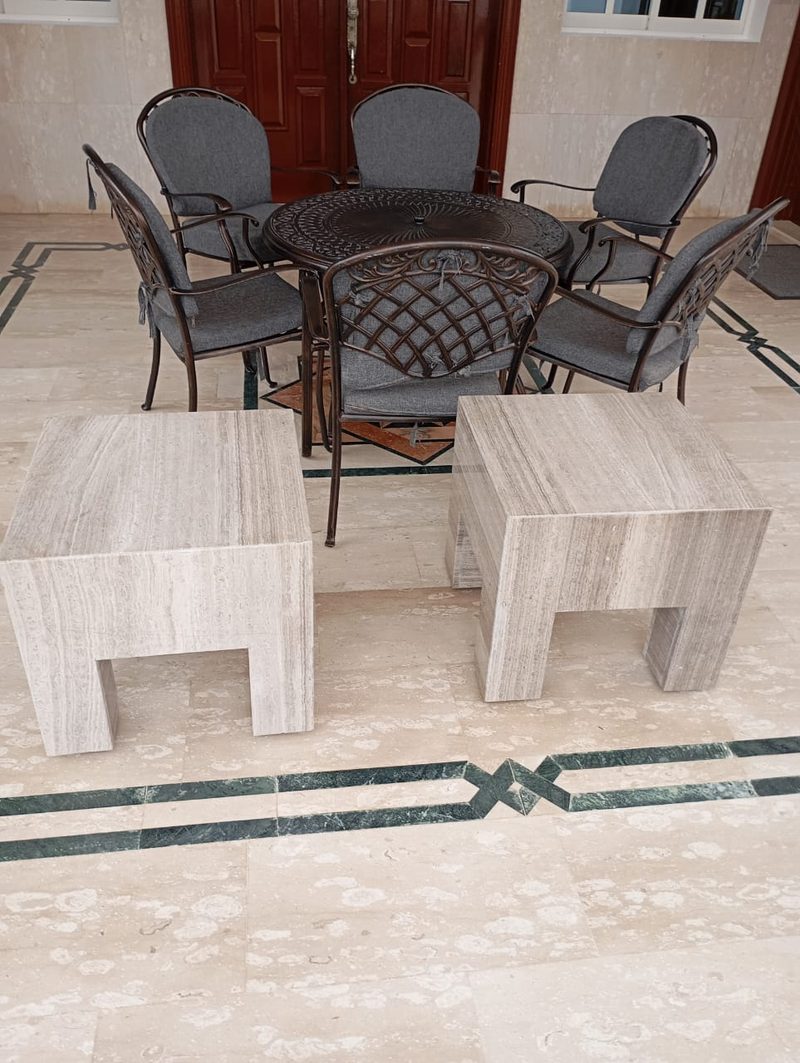 Pair of stone side tables on a terrace with an inlaid floor border — Reef Al Ghadeer, Al Ain